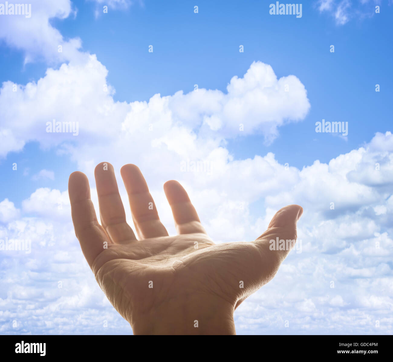 Opened hand raised to heaven in waiting for something. Depth of field with focus on palm. Clipping path included. Stock Photo
