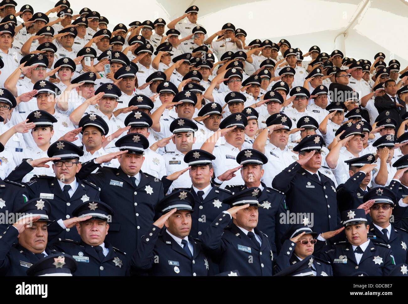 Mexican Federal Police officers salute during the 88th anniversary of the national police force attended by President Enrique Pena Nieto July 13, 2016 in Iztapalapa, Mexico City, Mexico. Stock Photo