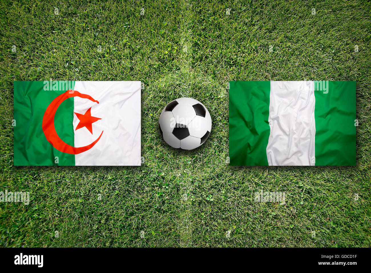 Algeria vs. Nigeria  flags on green soccer field Stock Photo