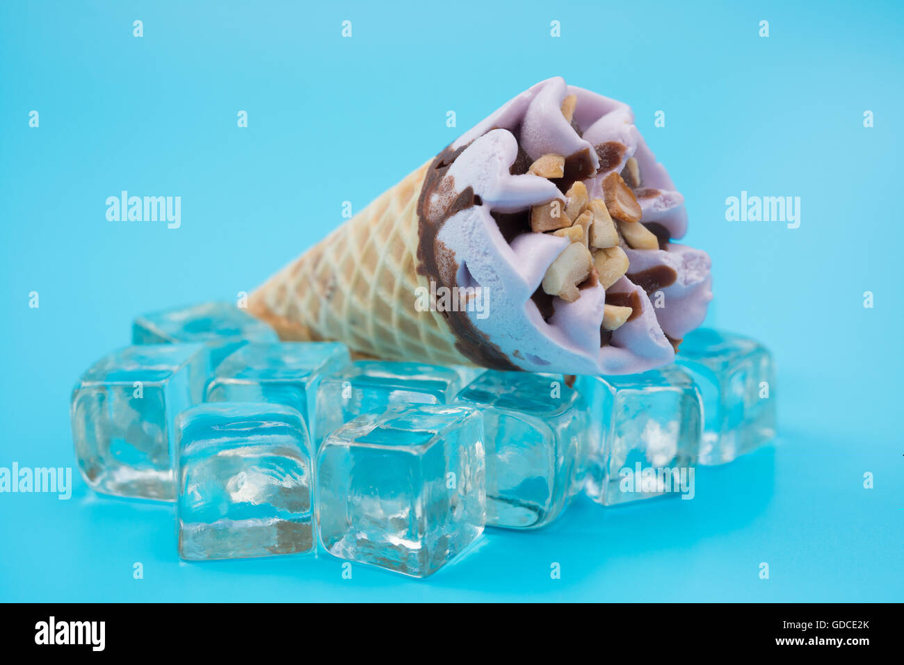 peanut flavor ice cream cone on top of ice cubes on blue background