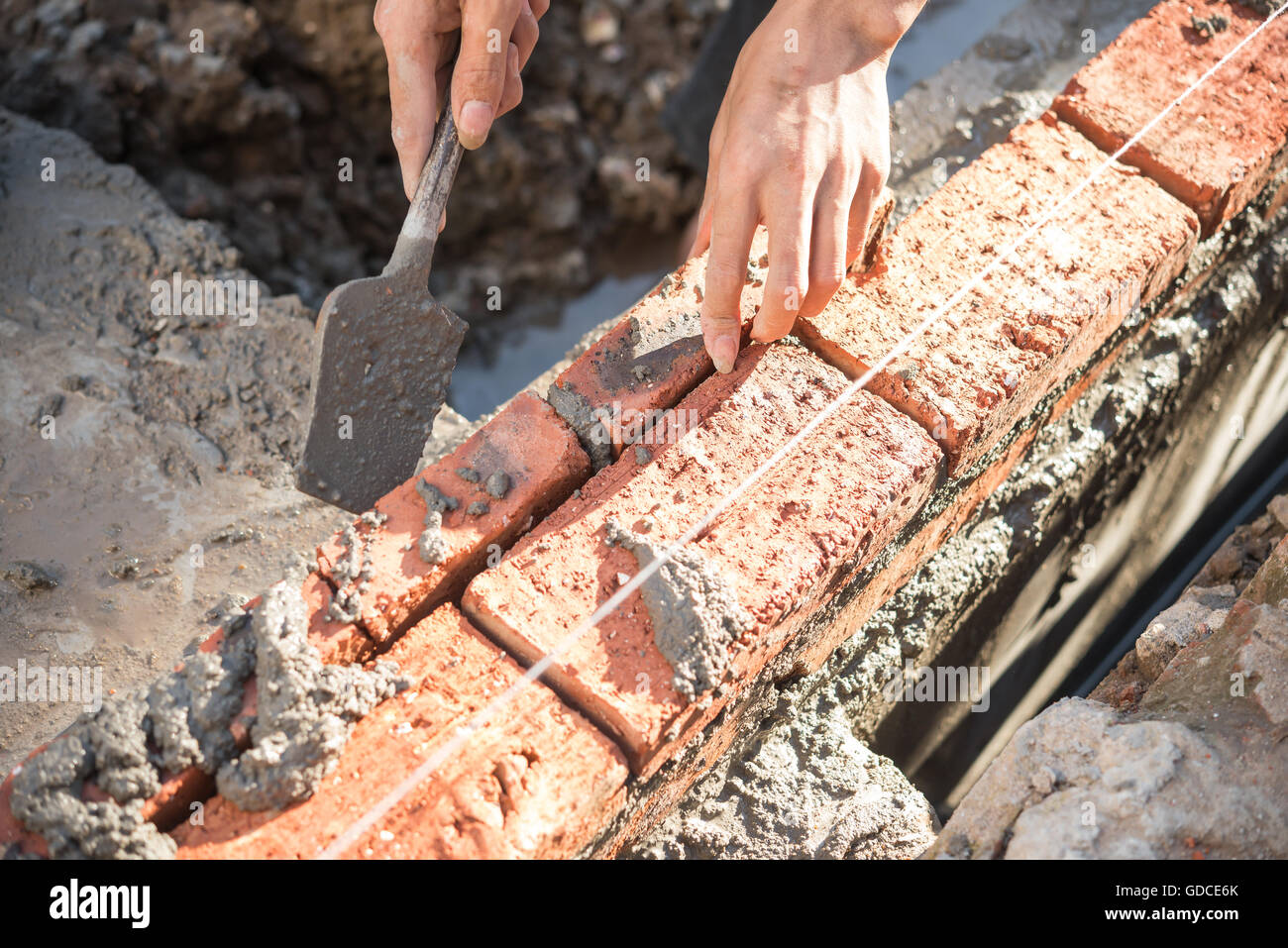 plasterer making up a brick wall with cement Stock Photo