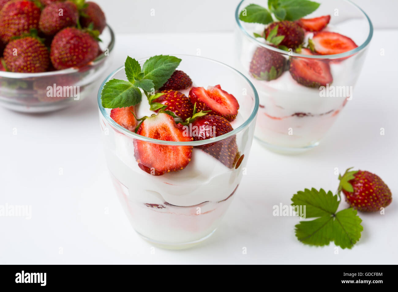 Fresh strawberries dessert layered with yogurt on white background