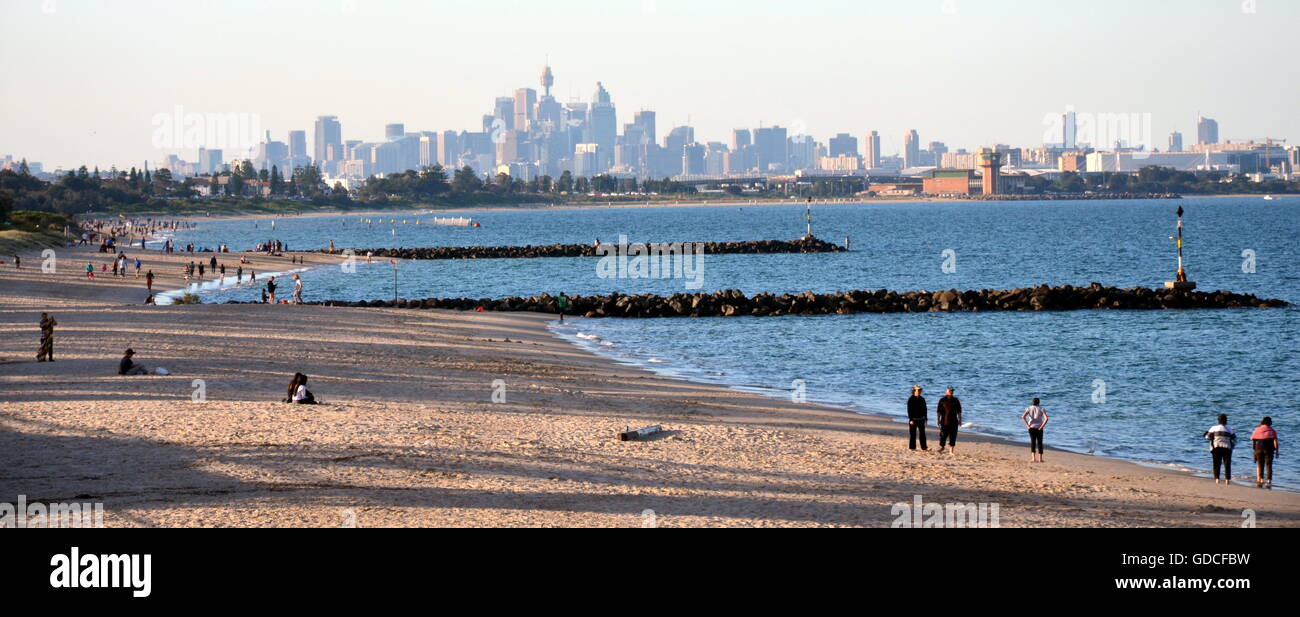 Sydney, Australia - Apr 21, 2014. People relaxing at Brighton le Sands beach on Easter Monday. Sydney city view in the backgroun Stock Photo