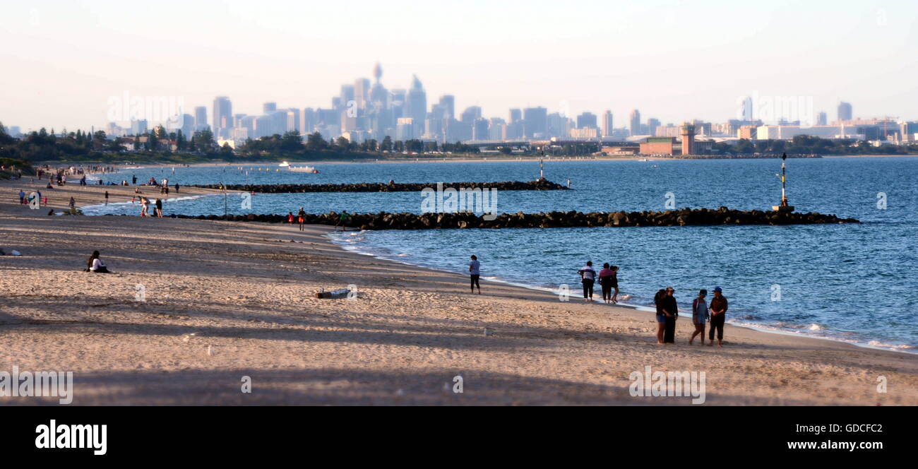 Sydney, Australia - Apr 21, 2014. People relaxing at Brighton le Sands beach on Easter Monday. Sydney city view in the backgroun Stock Photo