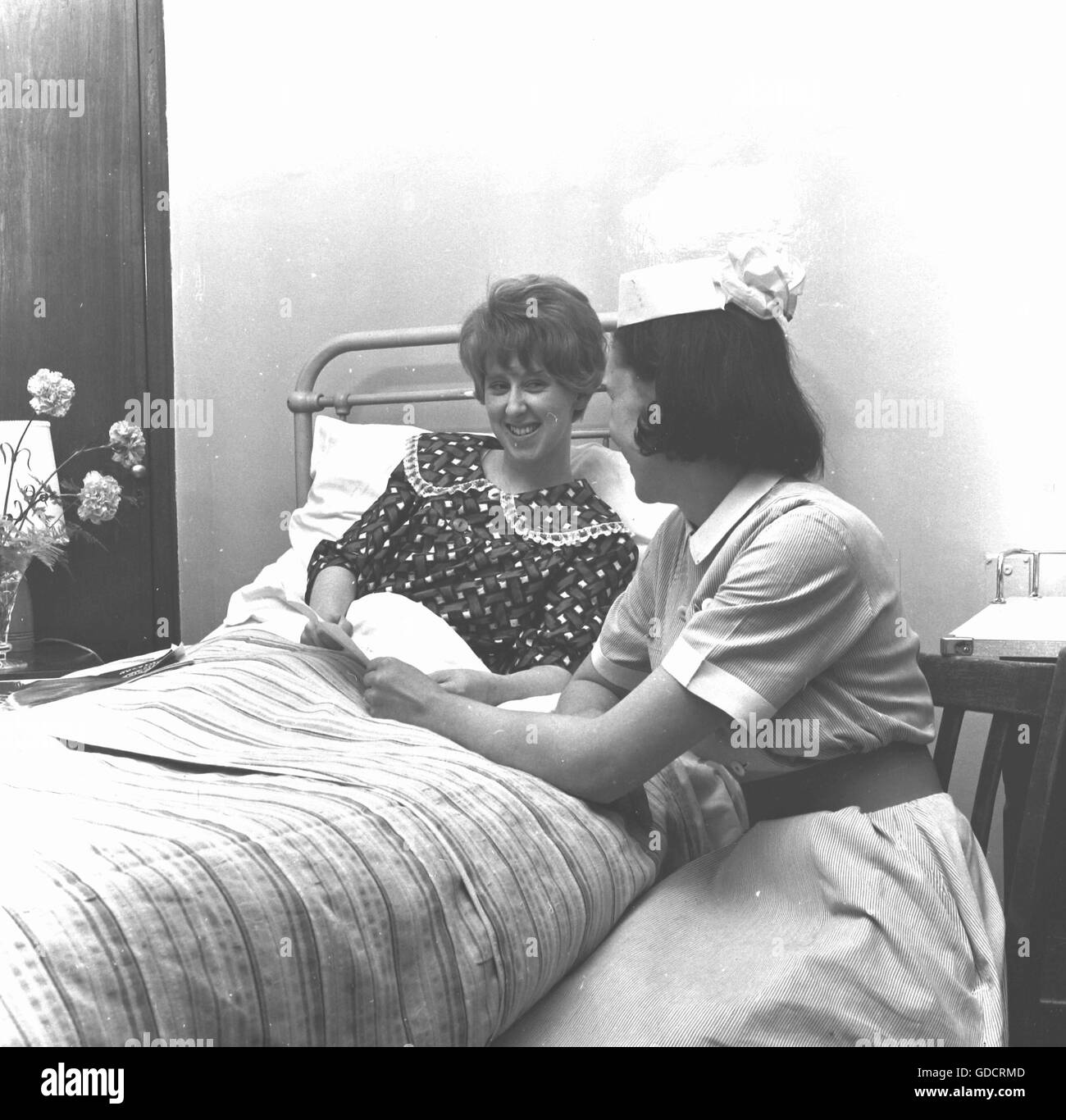 Bed side care for a patient by a nurse. Nurses at a residential teaching hospital in Leicester c1962. Photograph by Tony Henshaw Stock Photo