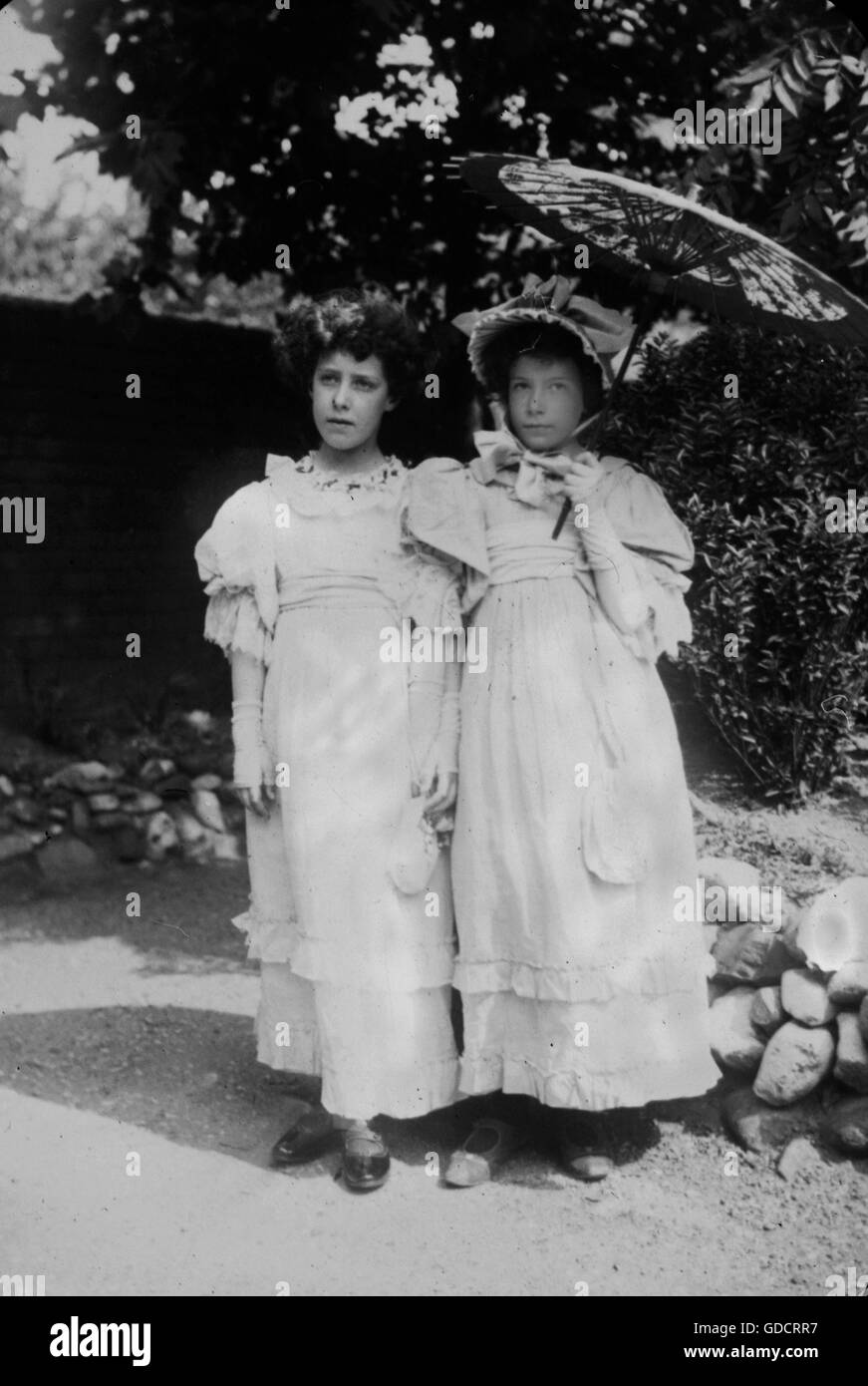 Two girls is summer frocks with parasol from a collection of amateur holiday photos c1899, venue appears to be Hastings. Photograph by Tony Henshaw -Taken from early original glass slides (original positive images). FROM THE 1899 HASTINGS FAMILY COLLECTION Stock Photo
