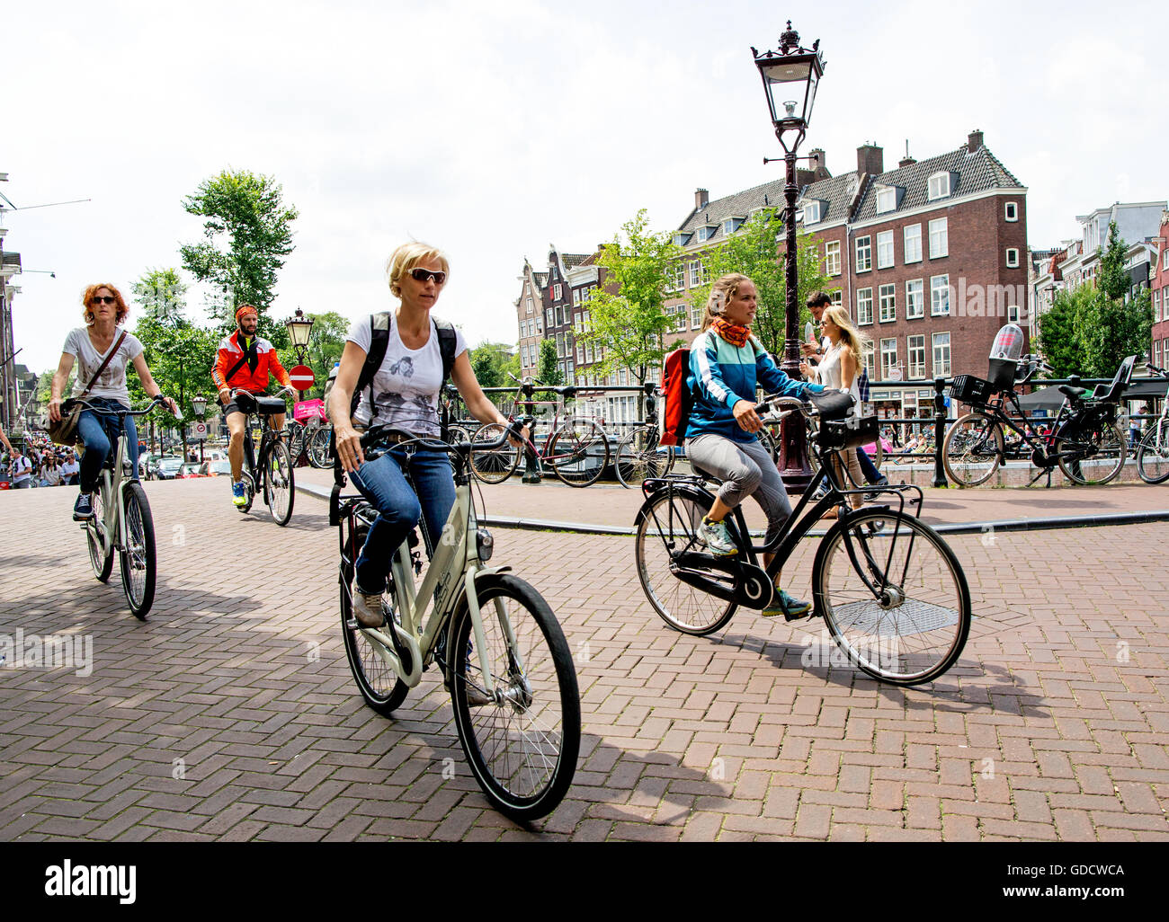 Tourists Cycling In Amsterdam Holland Stock Photo - Alamy