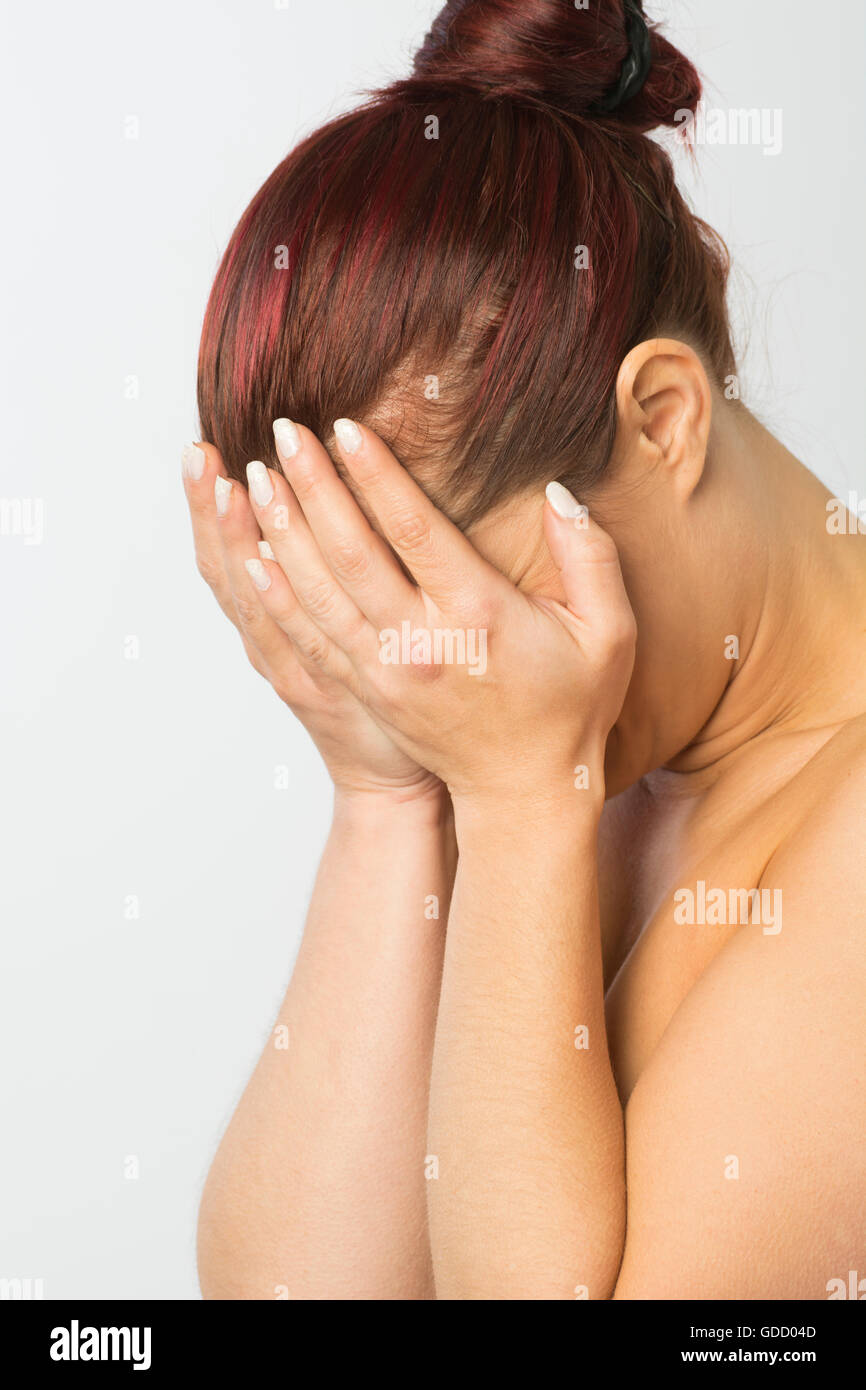 Redhead woman hiding face with hands Stock Photo