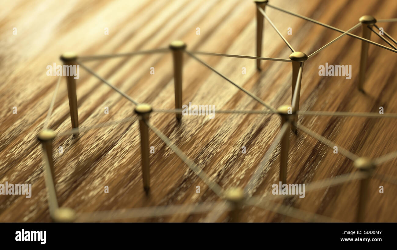 Network, networking, connect, wire. Linking entities. Network of gold wires on rustic wood. Nails connected with tether. Team work, team loyalty, team Stock Photo