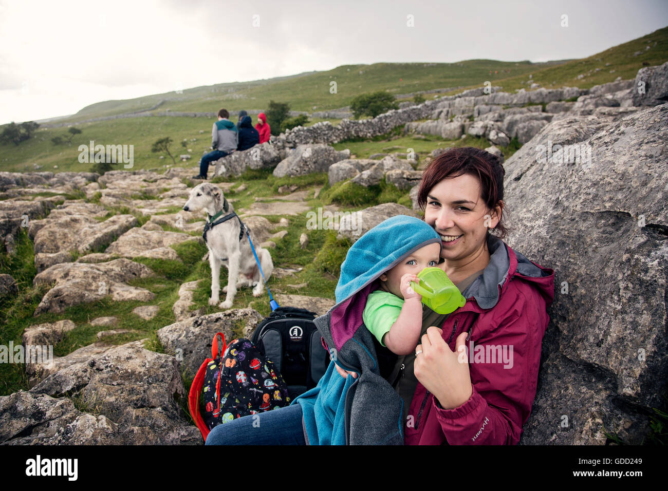 Mother, baby and dog out on a walk taking a break / breather above Malham Cove on the Limestone Pavement Stock Photo