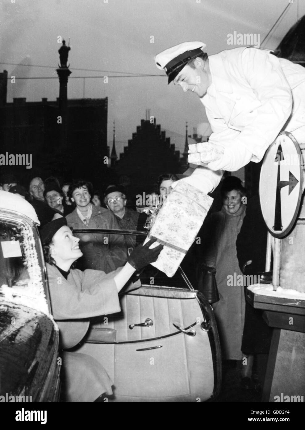 Hielscher, Margot, * 29.9.1919, German actress, half length, presenting Christmas packege to traffic policeman, Marienplatz, Munich, 21.12.1953, Stock Photo