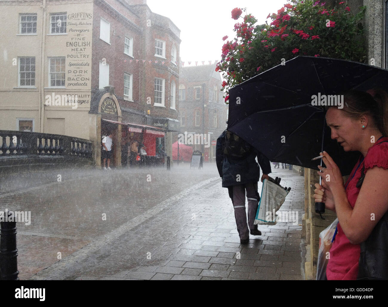 Shoppers sheltering from torrential rain in the town of Newbury, Berkshire, UK Stock Photo