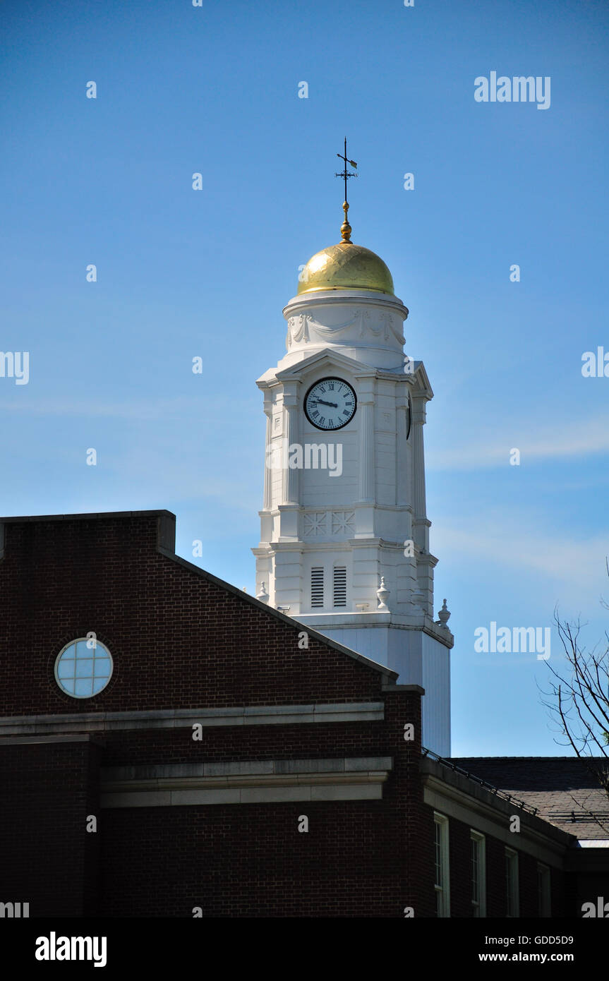 A white clock tower rising above buildings in West Hartford