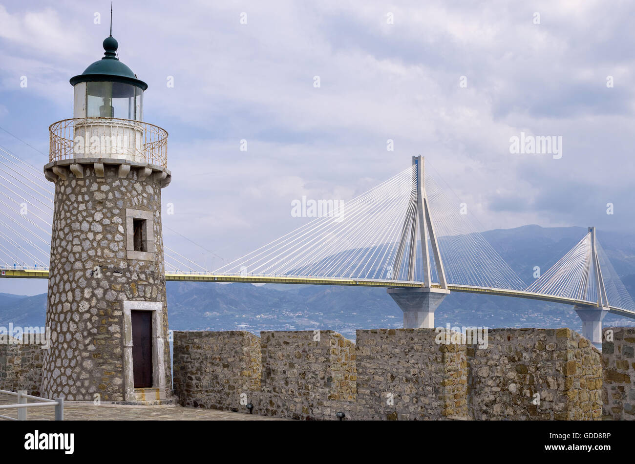 Old lighthouse versus modern cable bridge in Greece Stock Photo