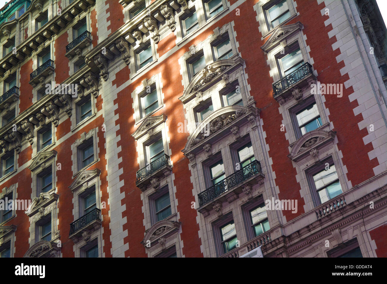 The side view of an orange and white bricked Manhattan, New York apartment building with rustic ornate and Victorian design Stock Photo