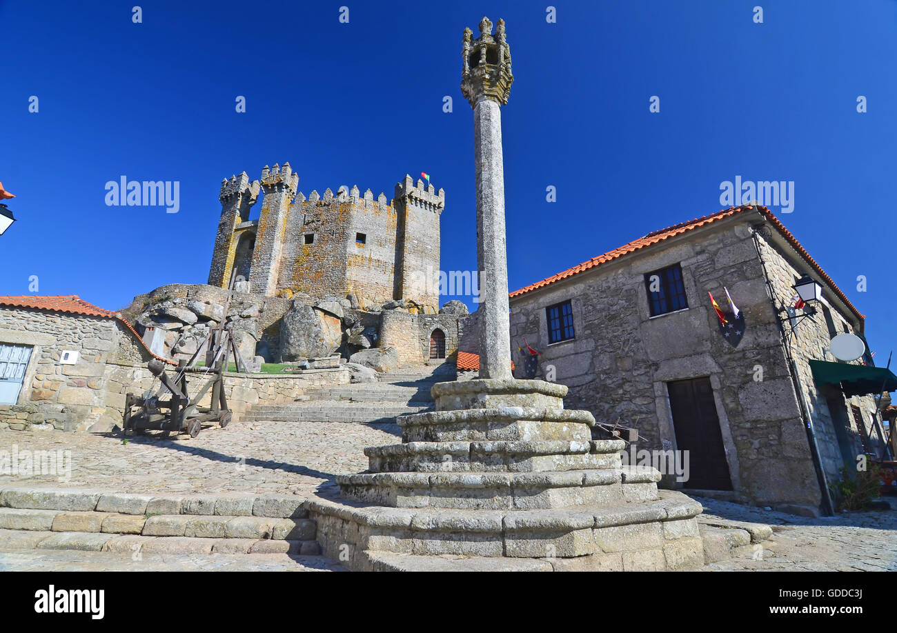 Medieval pillory used for attaching criminals to and administering punishments,with castle in the background. In Penedono,nort Stock Photo