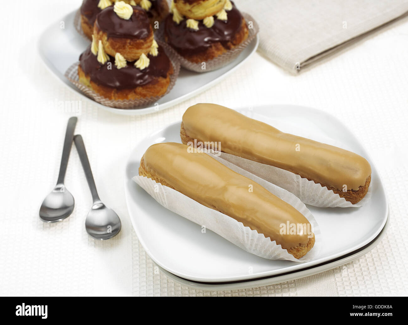 Plate with french cakes called chocolate religieuse and coffe eclair hires stock photography