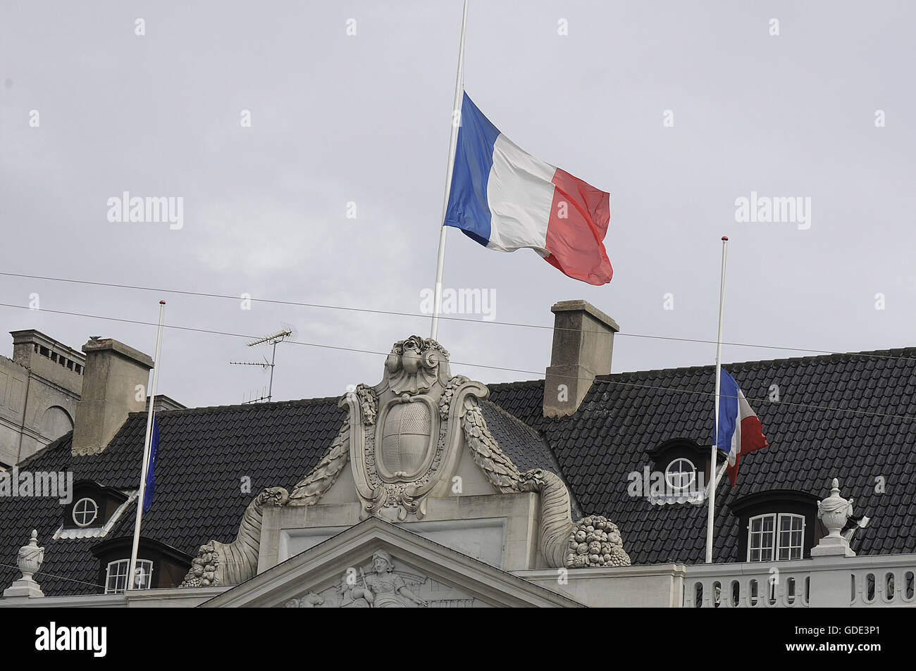 Copenhagen, Denmark. 16th July, 2016.-European union and French flags at half mast at french embassy and people are puring with flowers to pay tribute and stand solidatry with Frnech victims dies in terrorist attacked in Nice France on French national day on july 14, 2016 Credit:  Francis Joseph Dean/Dean Pictures/Alamy Live News Stock Photo