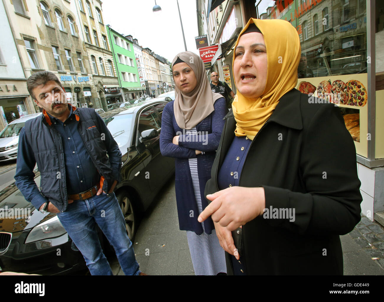 Cologne, Germany. 15th July, 2016. Turkish family Sonmez, Selcan and Aysel Meral (l-r), answer the questions of the dpa-correspondent on Keupstreet in Cologne, Germany, 15 July 2016. The Turkish military had attempted a coup the night before. Photo: Roland Weihrauch/dpa/Alamy Live News Stock Photo