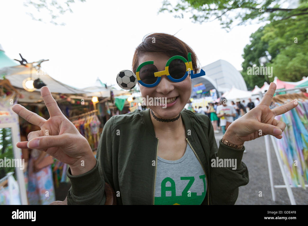 Tokyo, Japan. 16th July, 2016. A woman enjoys the Festival Brasil 2016 at Yoyogi Park on July 16, 2016, Tokyo, Japan. The annual festival brings together Brazilian food and entertainment including Samba and Capoeira performers. Organized by the Camara de Comercio Brasileira no Japao the event runs until July 17. The Brazilian community is the third largest immigrant population in Japan. Credit:  Rodrigo Reyes Marin/AFLO/Alamy Live News Stock Photo