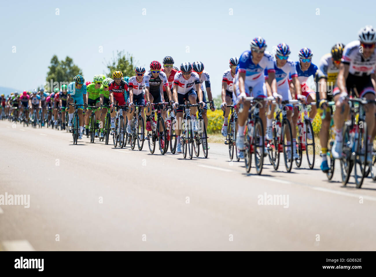 16th July, 2016. Montmeyran, FR. Riders in the peloton ride single file to shield themselves from the fierce headwind early in the stage. John Kavouris/Alamy Live News Stock Photo