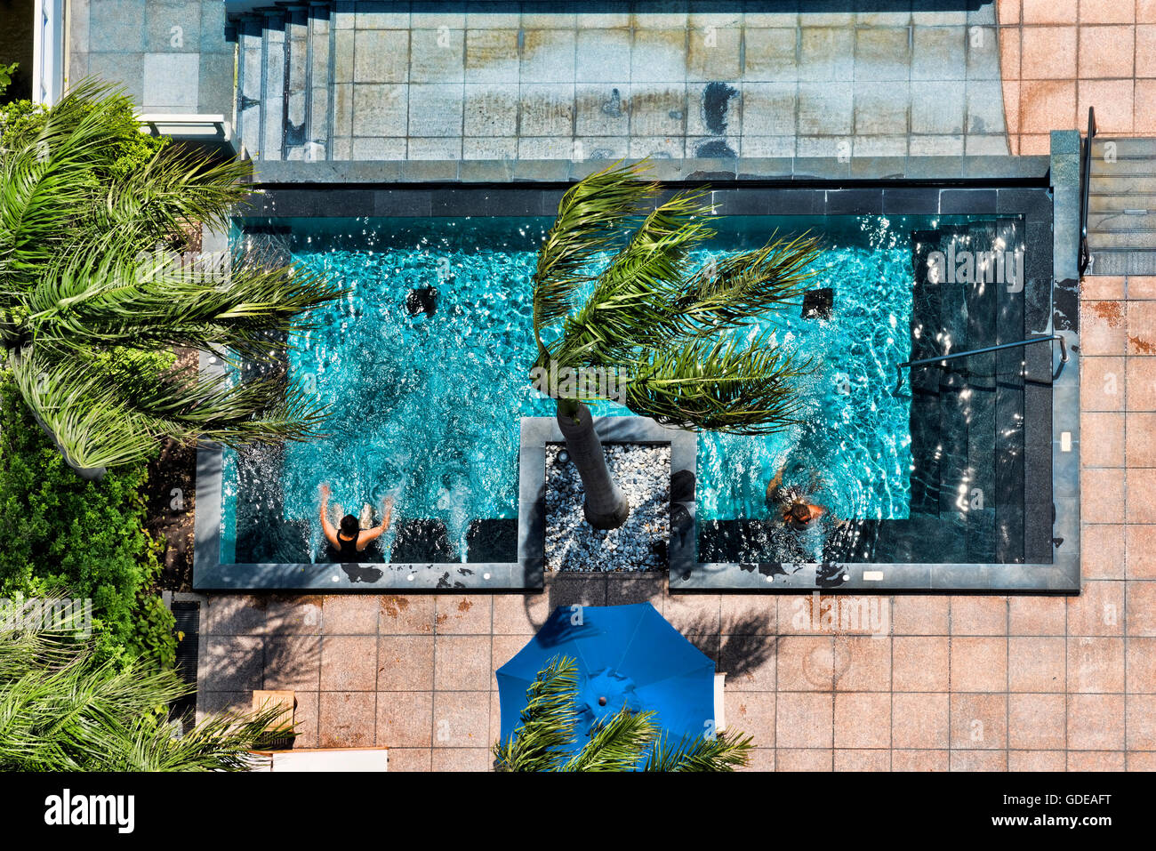 Guests sunbathing at a hotel swimming pool, Bangkok,Thailand Stock