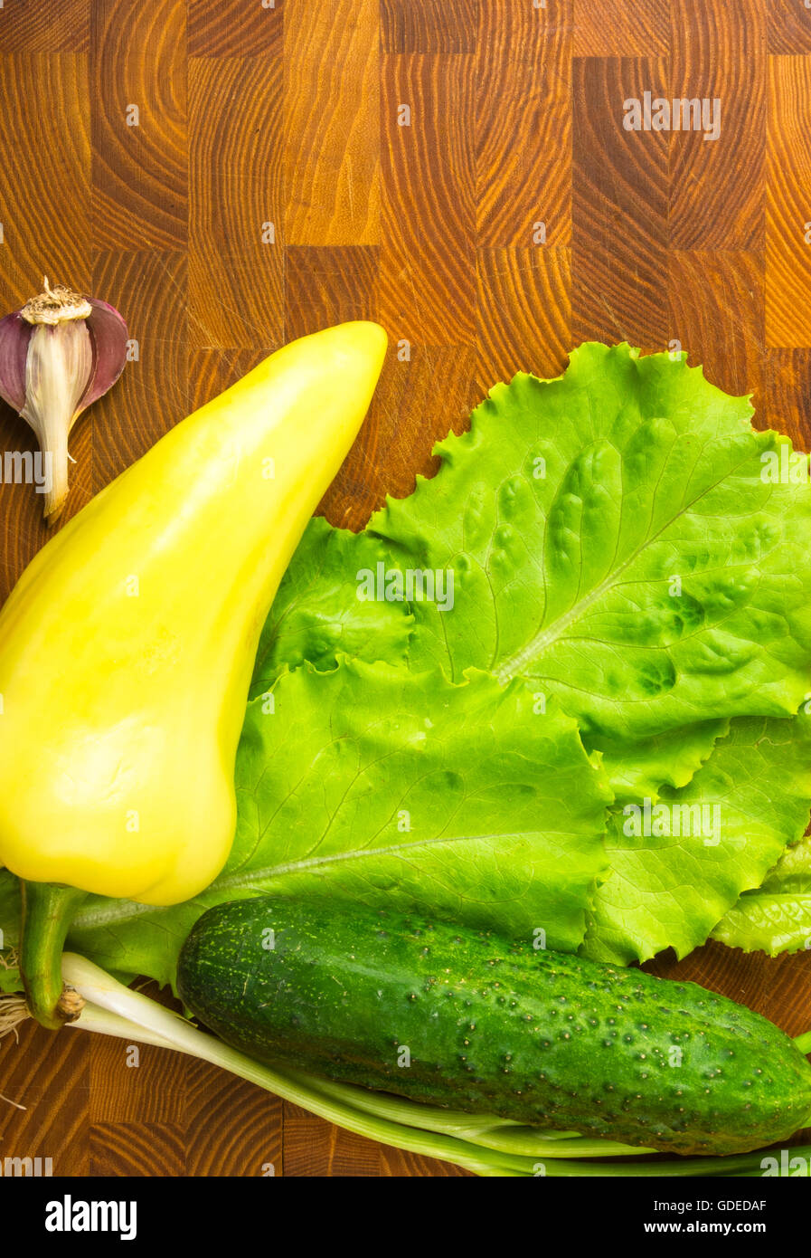 still life cucumber, yellow pepper, green onions, lettuce and garlic