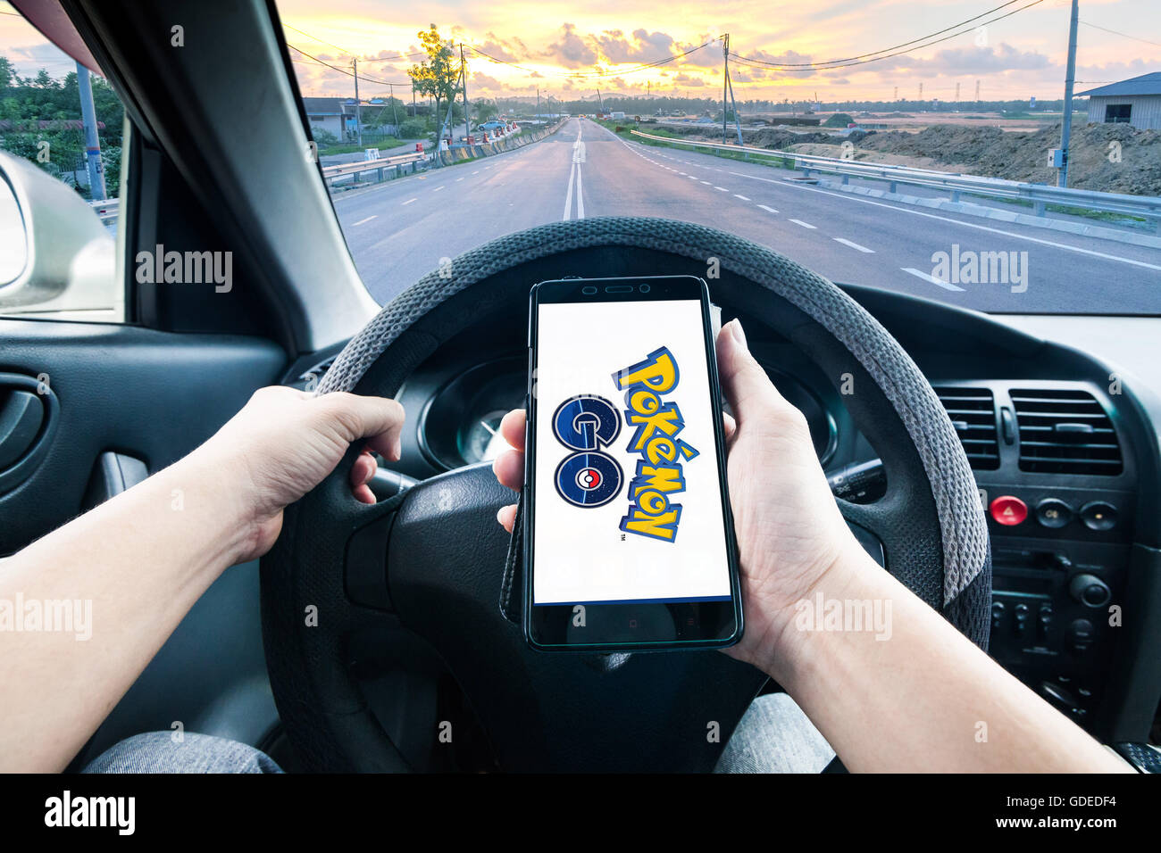 Woman sitting in a car and playing a Pokemon Go game Stock Photo - Alamy