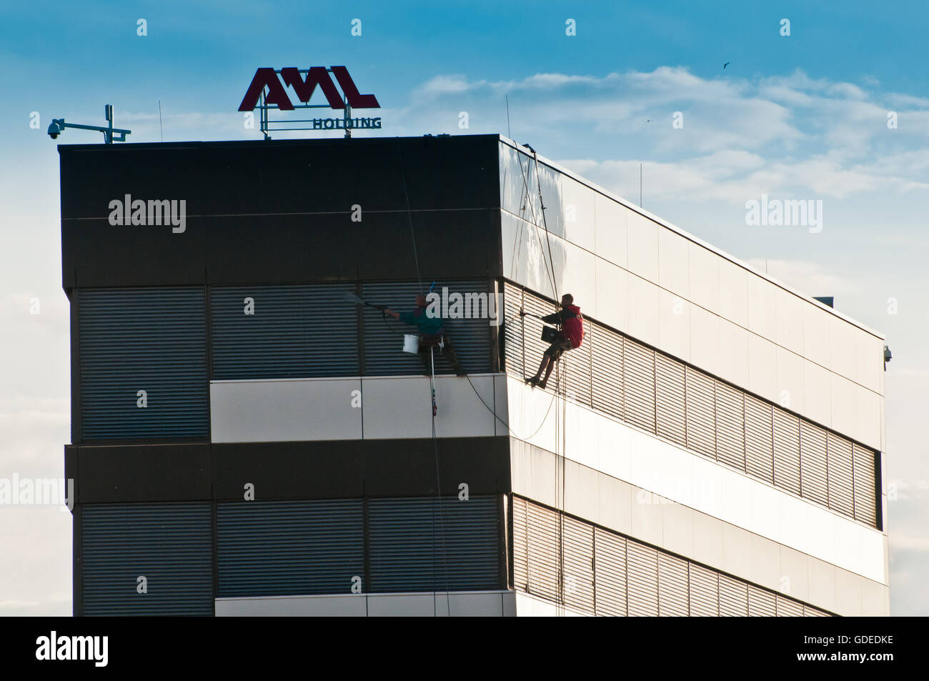 windows cleaners of modern building on rope Stock Photo