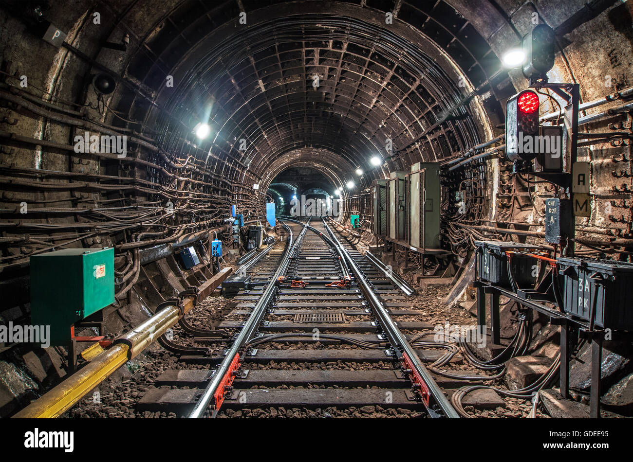 Traffic light with a red signal in the subway tunnel in front of the railway arrow Stock Photo