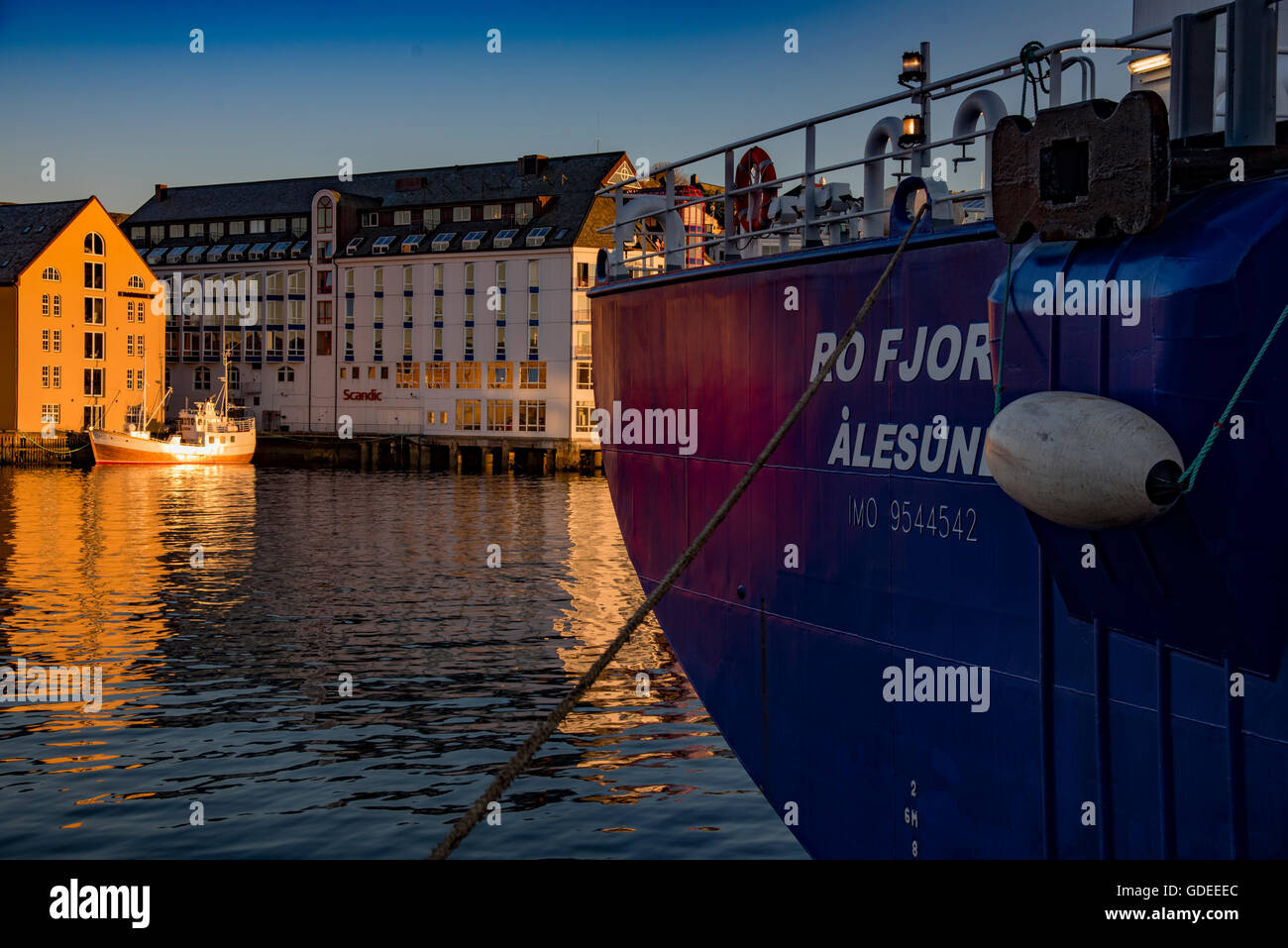 Ships docked in evening light. Brosundet Canal and hotels in background. Alesund, Norway, More og Romsdal, Scandinavia, European Stock Photo