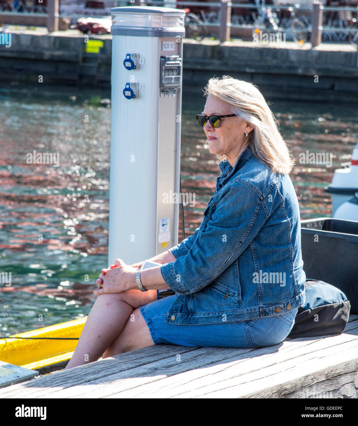 Woman relaxing at the Famous Bergen Fish Market on the waterfront. Bergen, Norway, Hoardaland Stock Photo