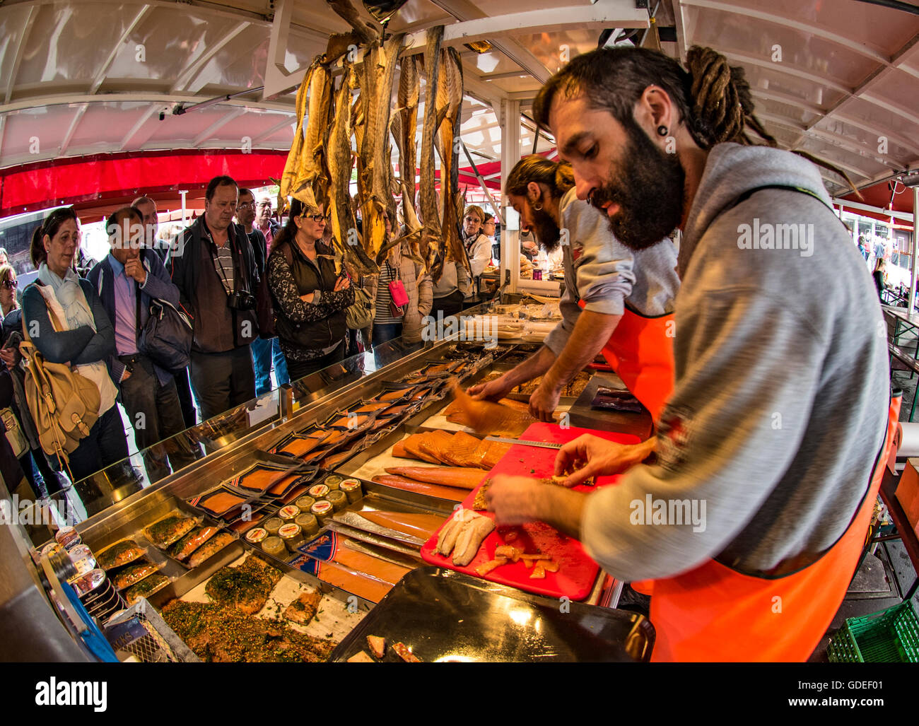 Fisherman preparing samples of fish for tourists in stall at the Famous Bergen Fish Market, Bergen, Norway, Hordaland, Stock Photo