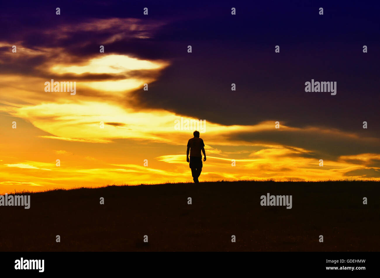 Silhouette of man walking at sunset Stock Photo - Alamy