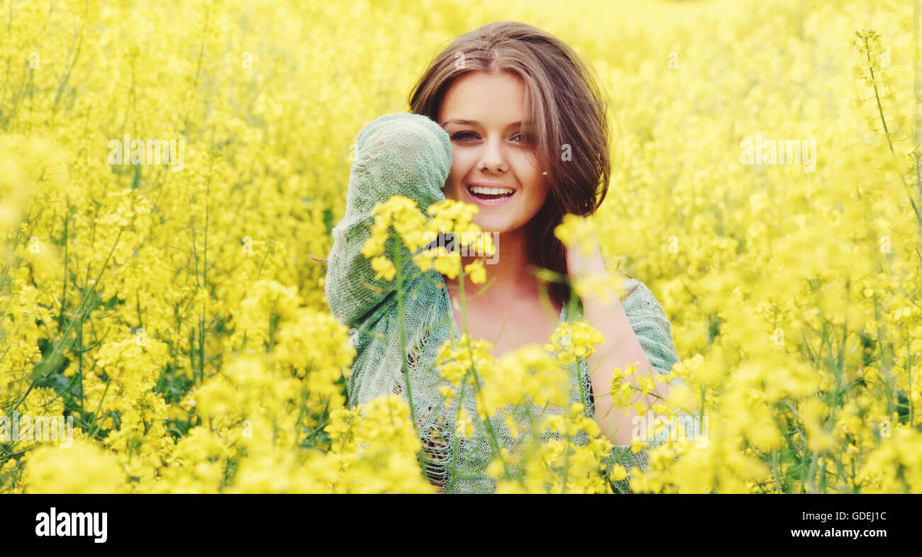 Smiling Teenage girl standing in field of yellow flowers, Brugg, Aargau, Switzerland Stock Photo