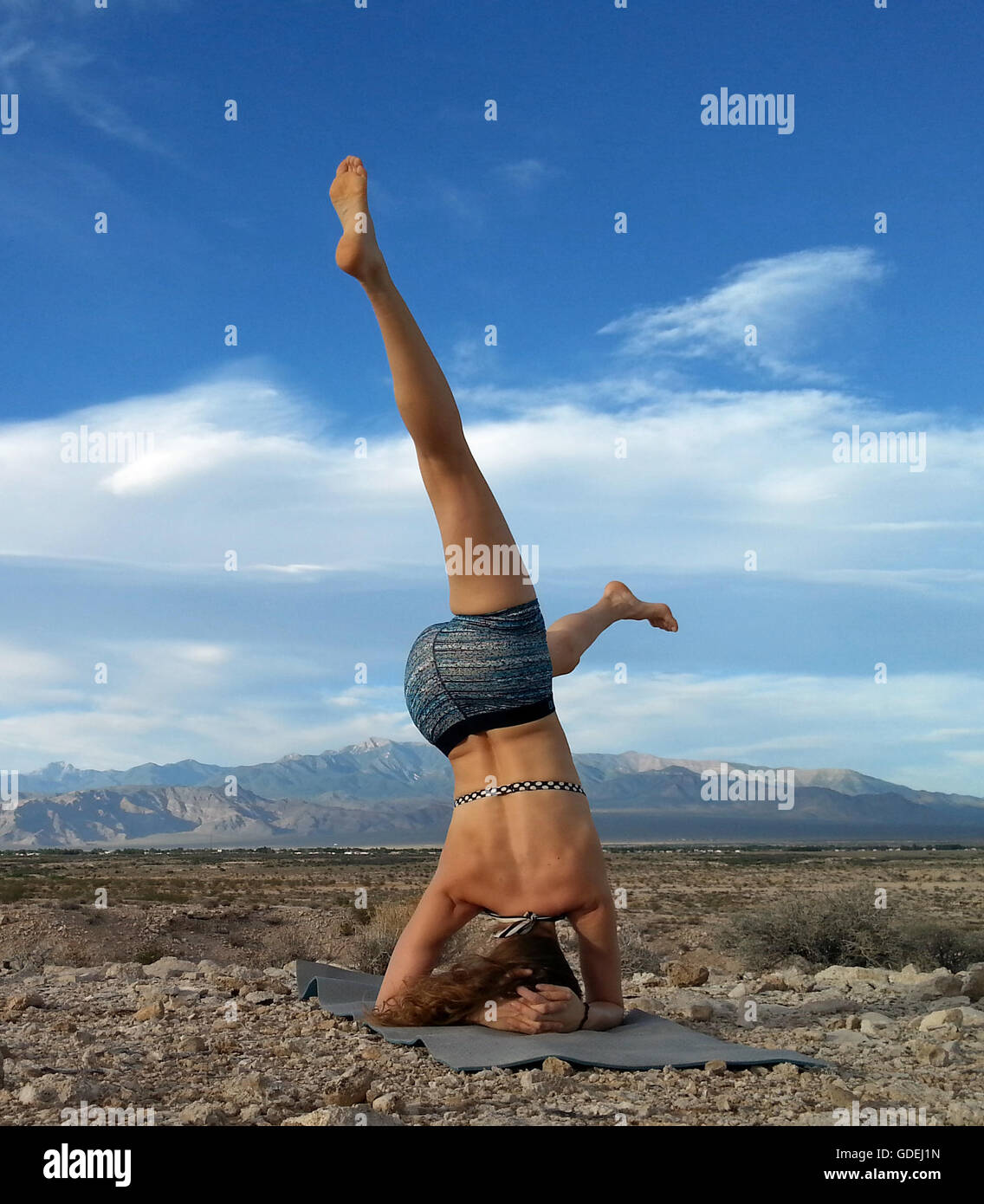 Women doing a head stand in the desert, Nevada, United States Stock Photo