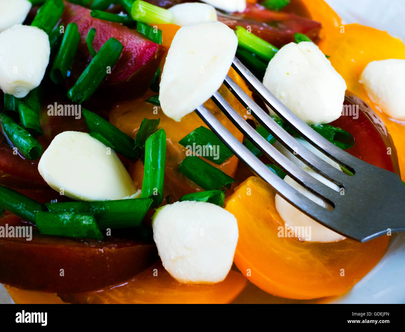black and yellow tomato salad with spring onion and goats cheese Stock Photo