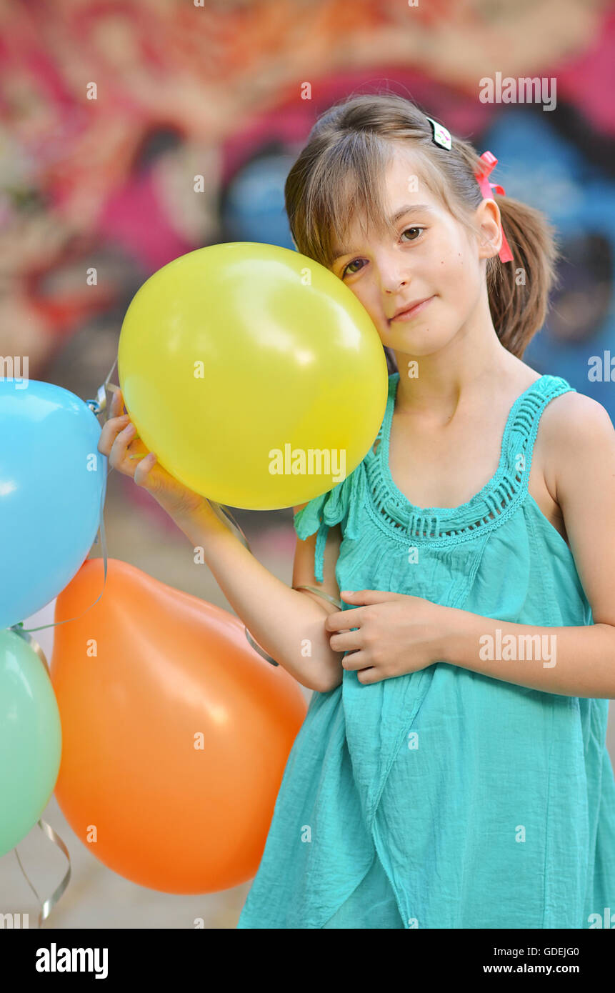 Girl holding bunch of balloons Stock Photo