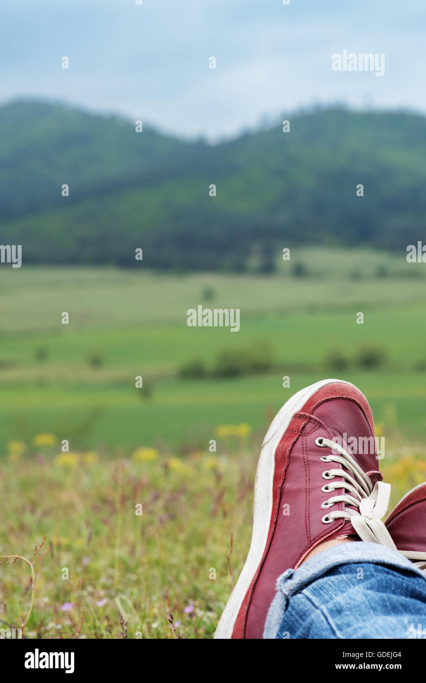 Close-up of person's legs, lying in a field Stock Photo