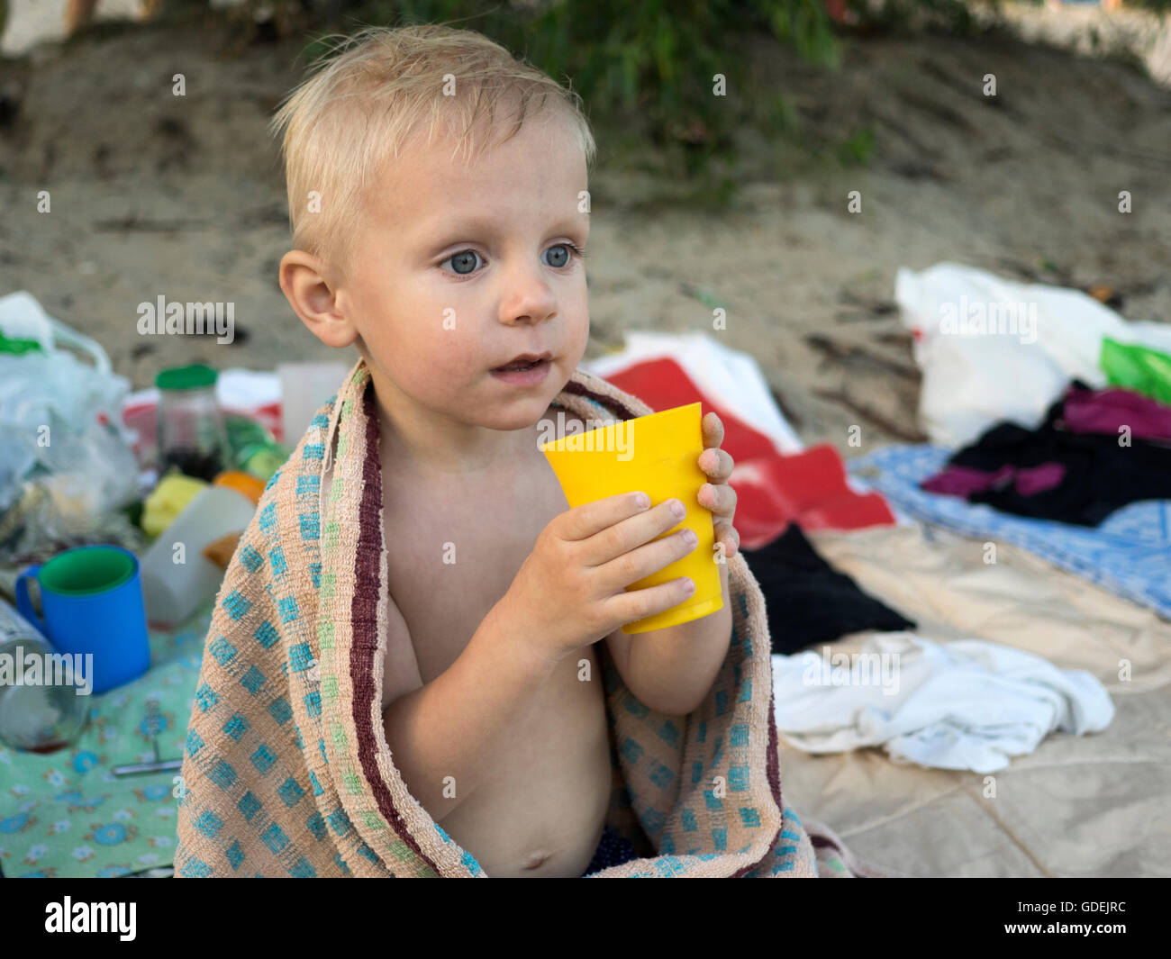 Boy on beach holding plastic cup Stock Photo