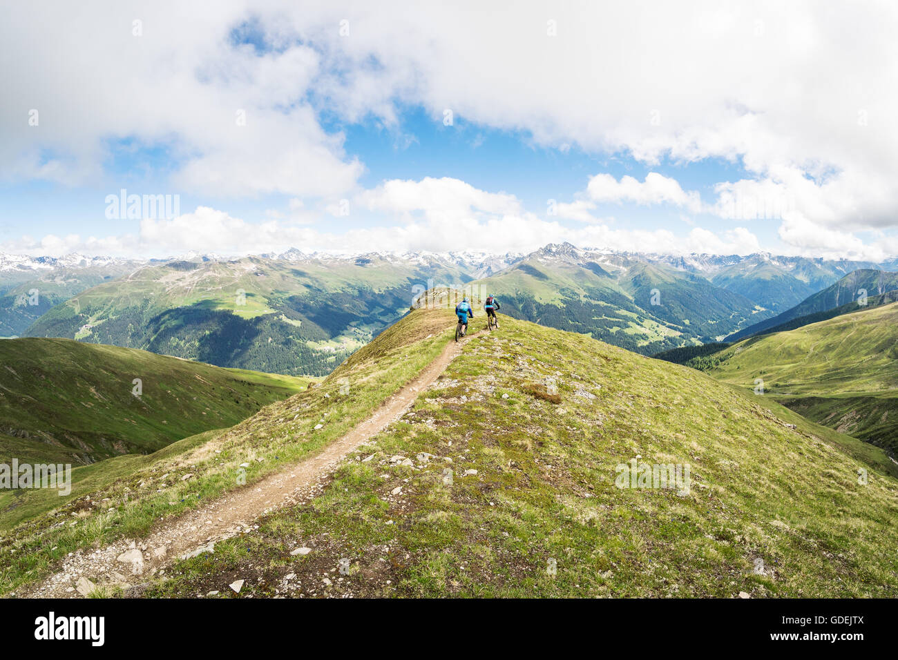 Man and woman mountain biking in swiss alps, Grindelwald, Switzerland Stock Photo