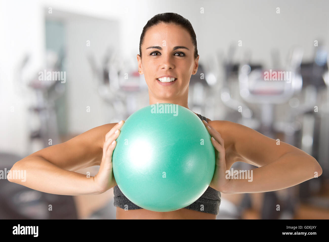 Fit woman standing and holding a pilates ball, in a gym Stock Photo - Alamy