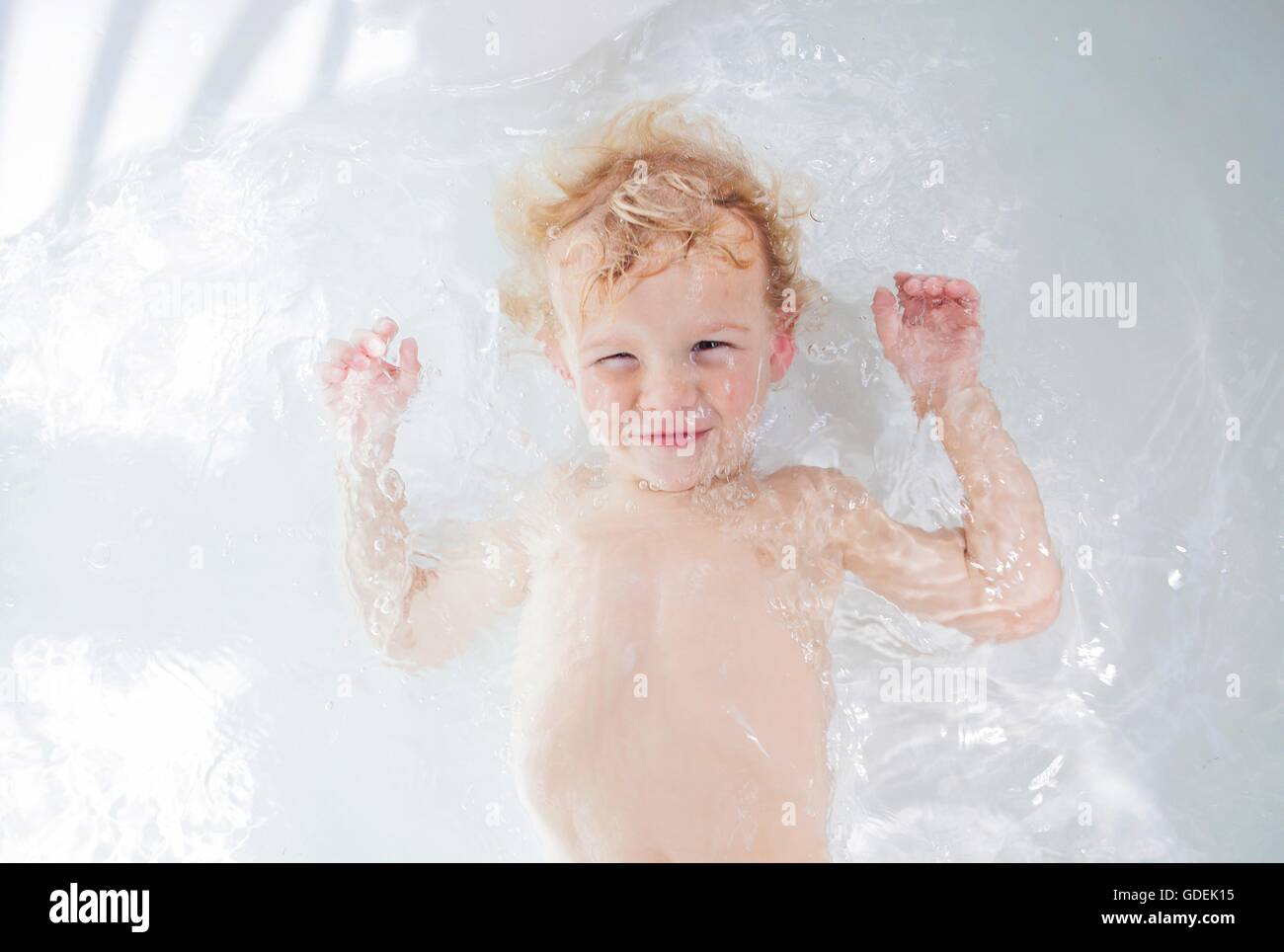 Boy lying in bath Stock Photo Alamy