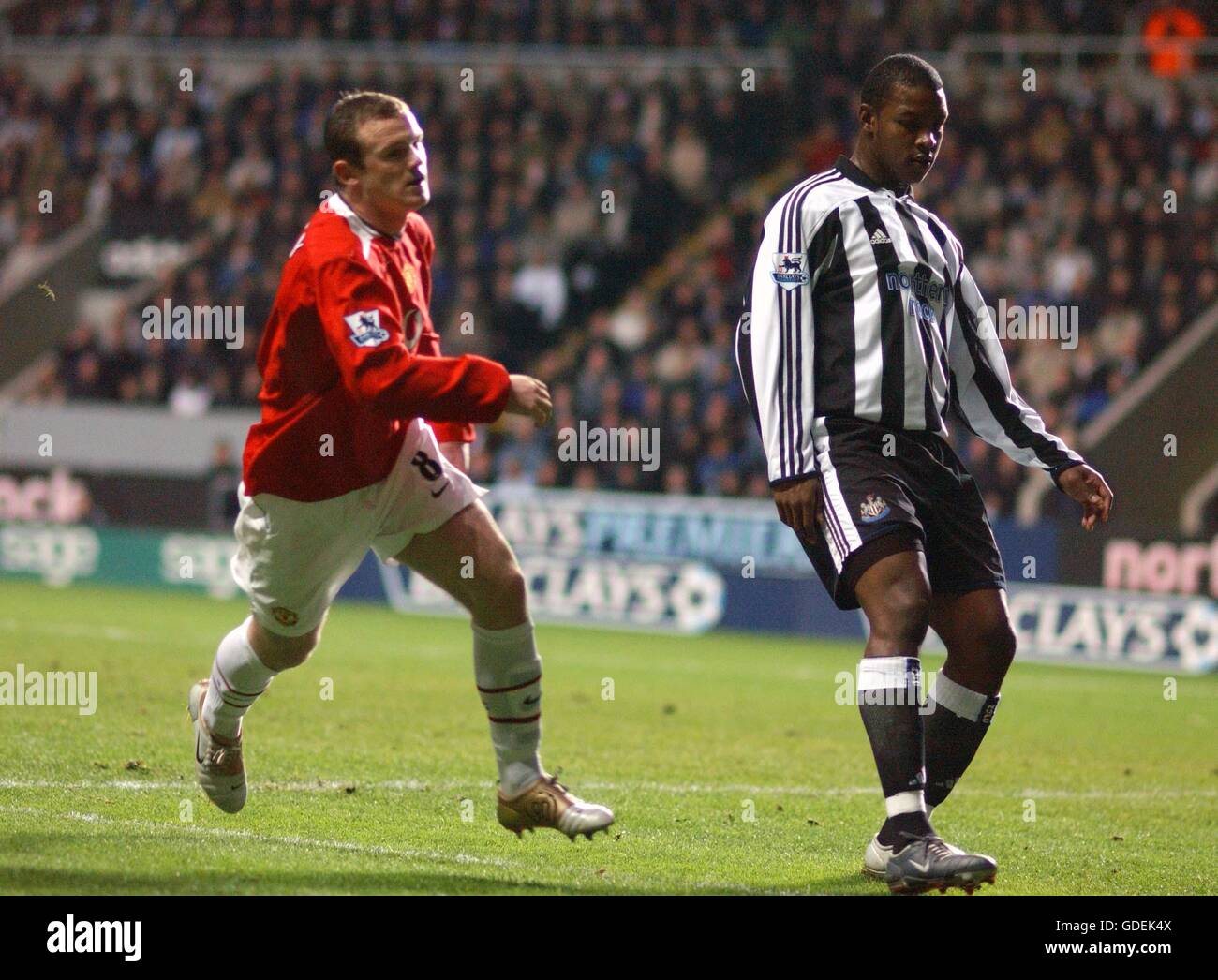 Newcastle United's Titus Bramble looks on dejected as Manchester United's Wayne Rooney turns away to celebrate after scoring their opening goal Stock Photo