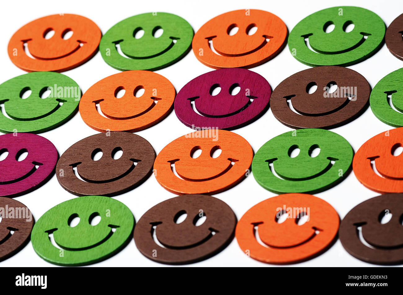 smiling wooden multi colored emoticons in row Stock Photo