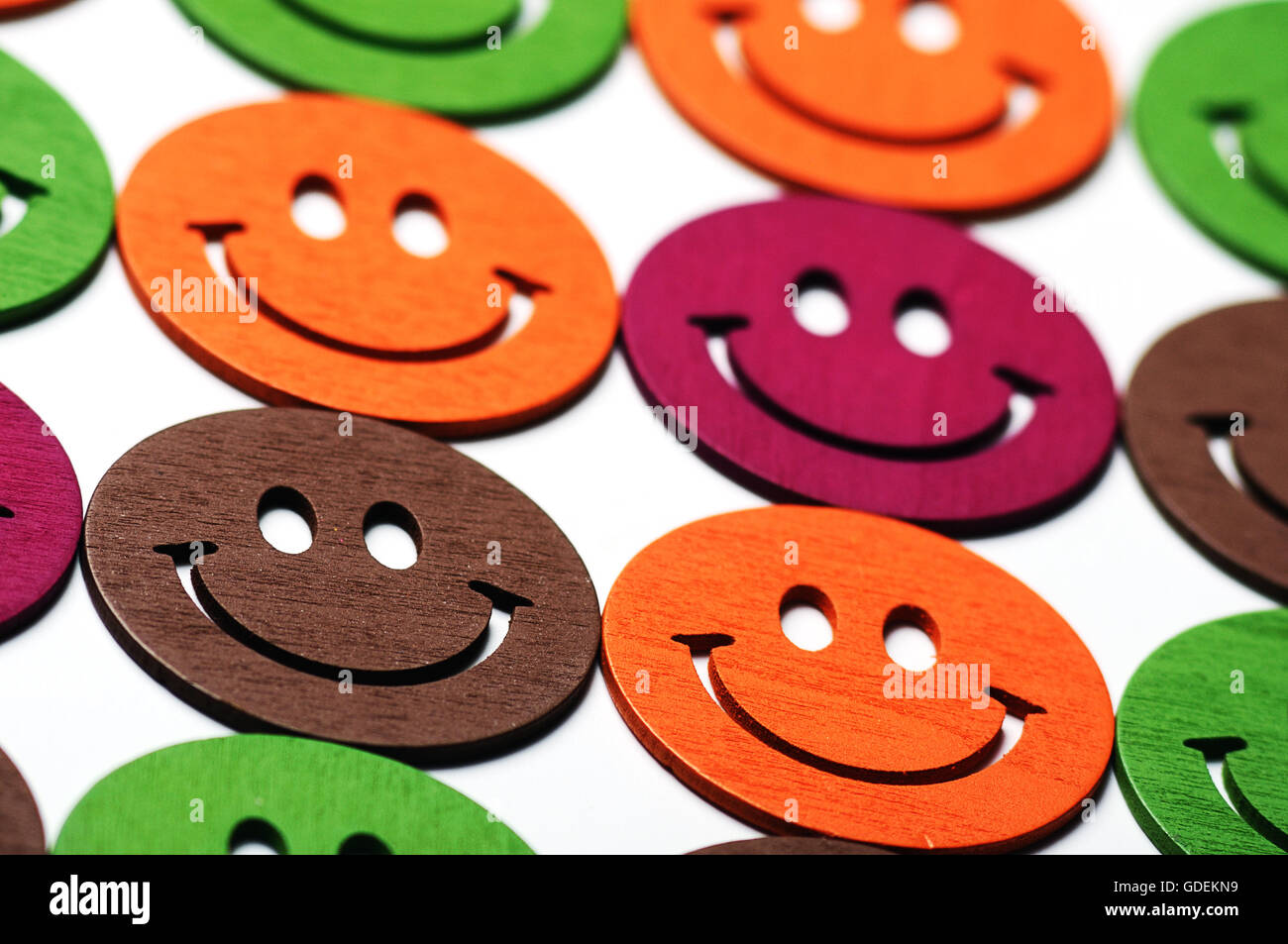 smiling wooden multi colored emoticons in row Stock Photo