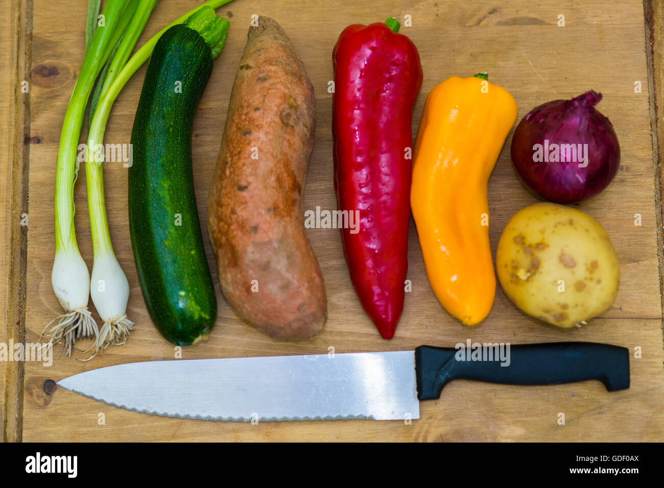 colourful mix of vegetables on a wooden board with knife. Vegan food. Veganuary. Healthy eating Stock Photo