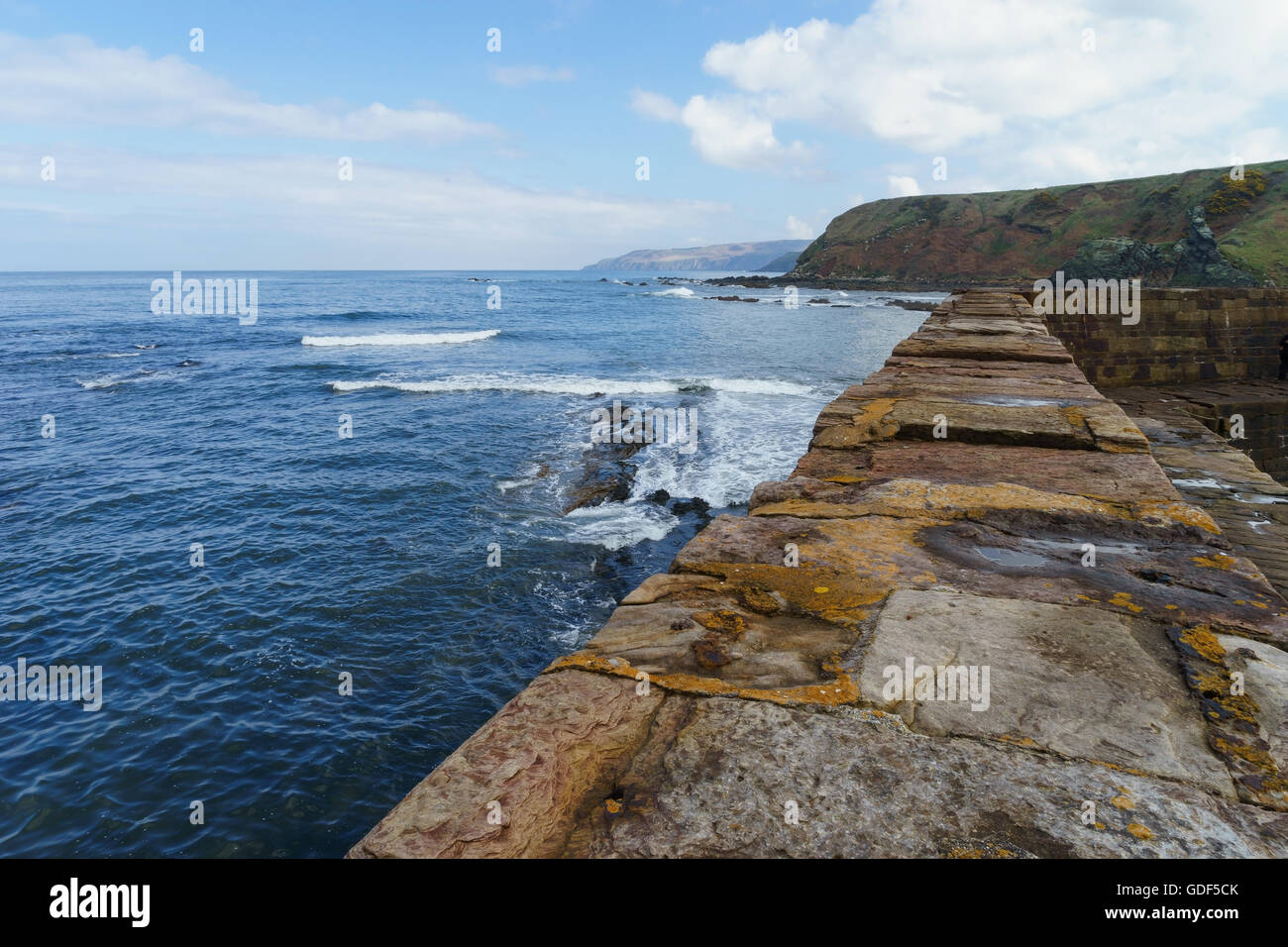 The stone breakwater at Cove Harbour, Scotland. Stock Photo