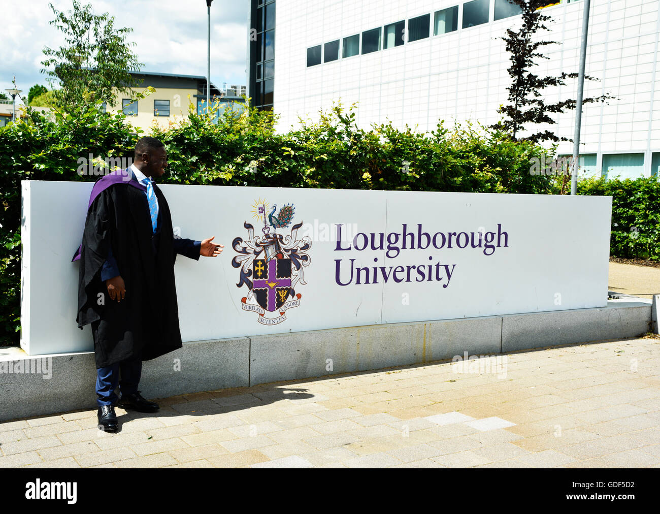 An International student in professional gown pointing Loughborough University on graduation day preparing to receive his educational qualifications. Stock Photo