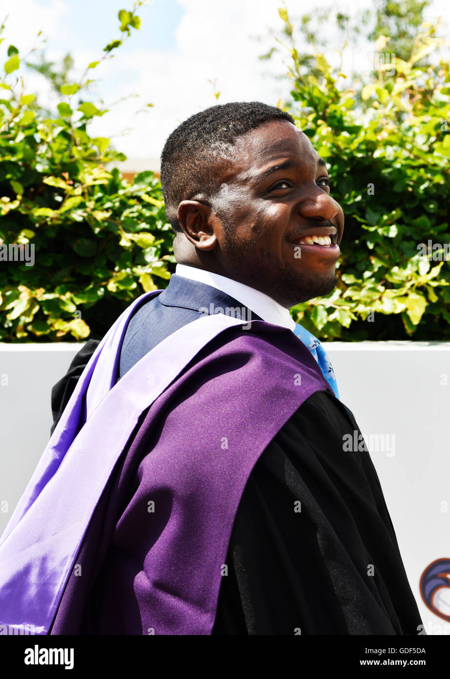 African male student in university professional gown graduating with great joy in qualifications suitable to his ambition for lifetime of future. Stock Photo
